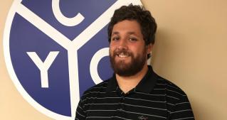 Vince Minniti stands in front of a CYO logo