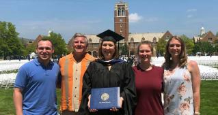 Colleen Corrigan Day stands on the quad with her family on commencement day