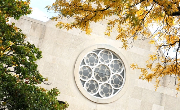 Fall leaves in front of stain glass window on chapel