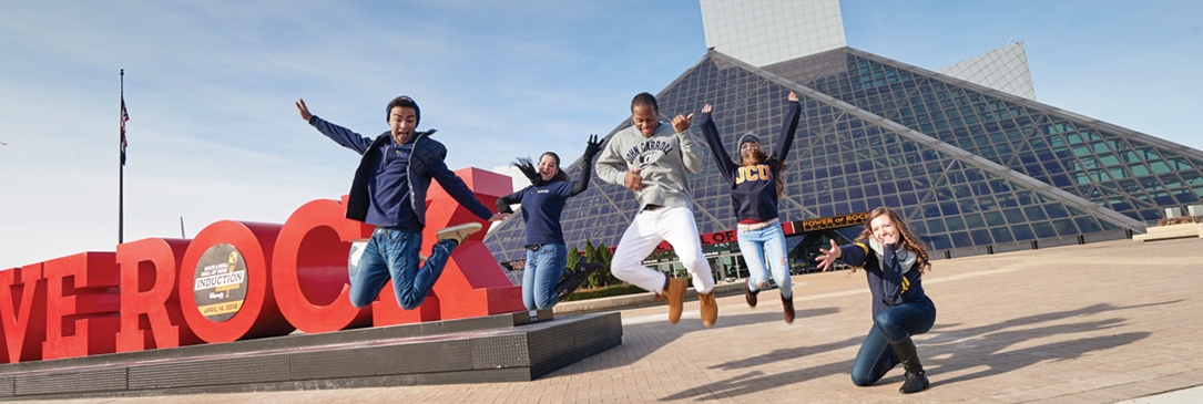 JCU students jumping in front of 'WE ROCK" sign